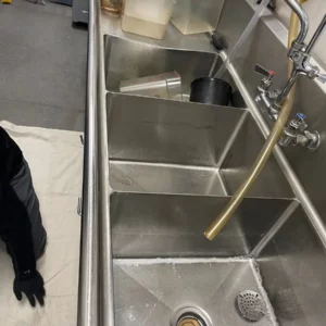 plumber beginning to inspect kitchen sink and future installation